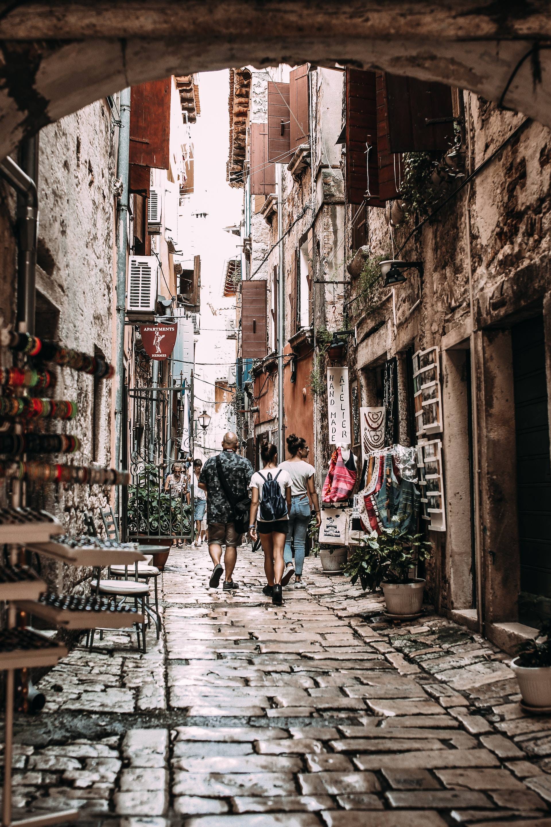 Cobble stone alley with people walking away from the viewer